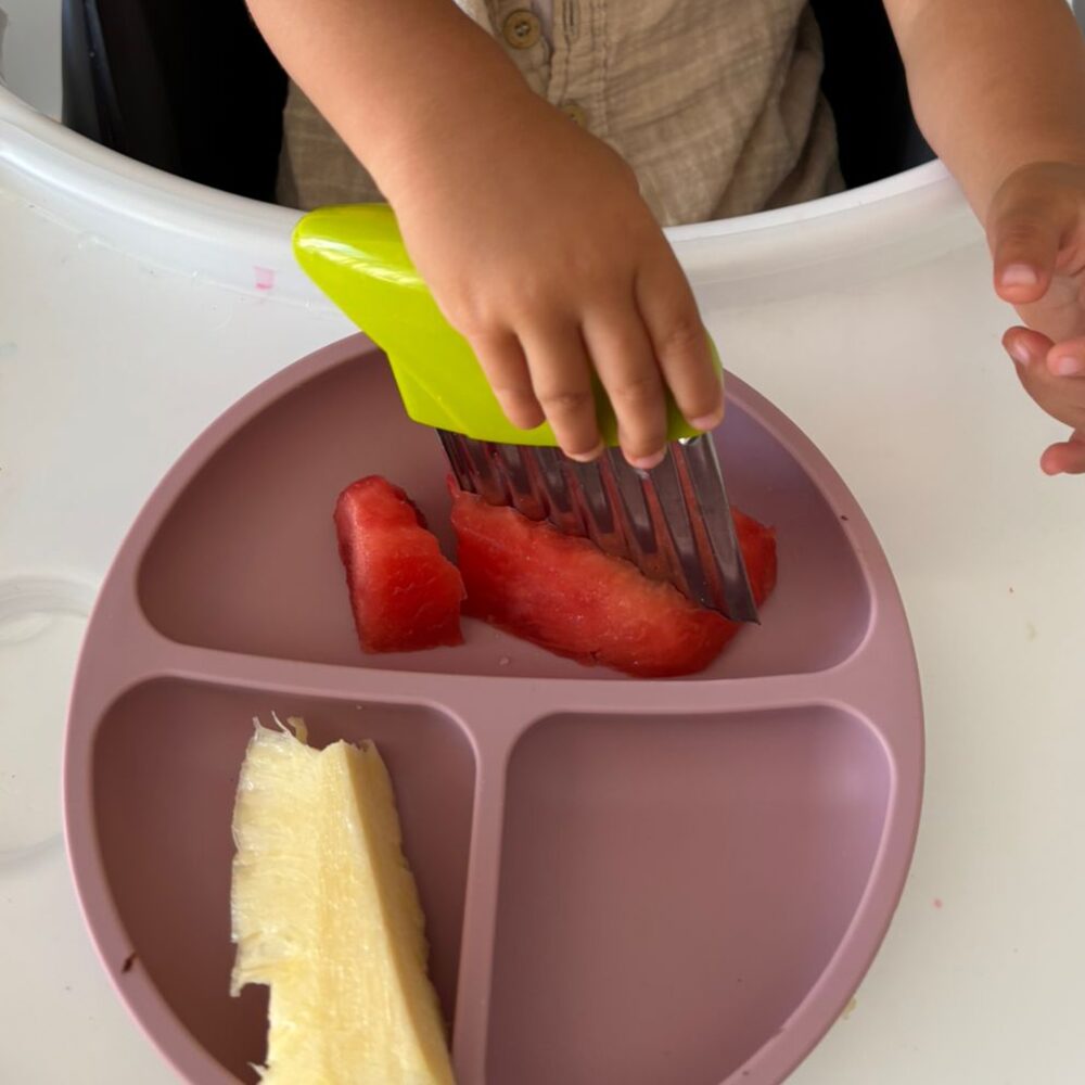 Crinkle-cutting watermelon on a divided plate